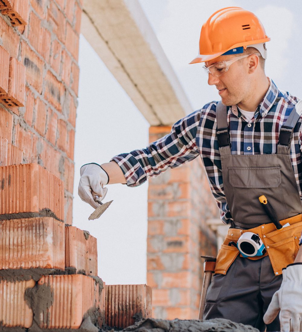 Young craftsman building a house